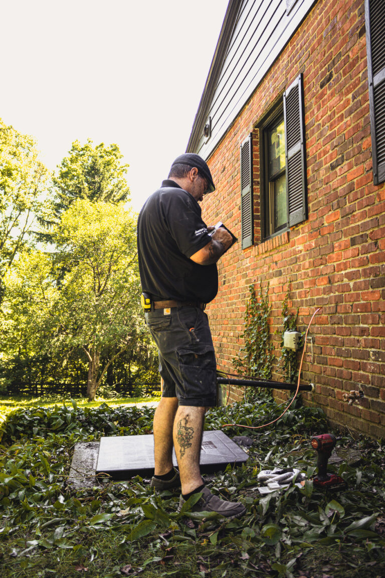 Professional HVAC technician installing central air system in house
